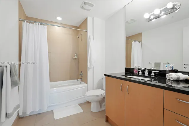 a bathroom with a double vanity sink toilet mirror and shower