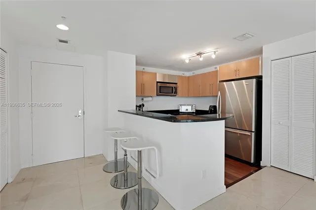 a kitchen with stainless steel appliances granite countertop a refrigerator and a stove top oven