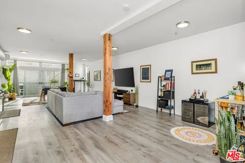 a living room with furniture wooden floor and a flat screen tv