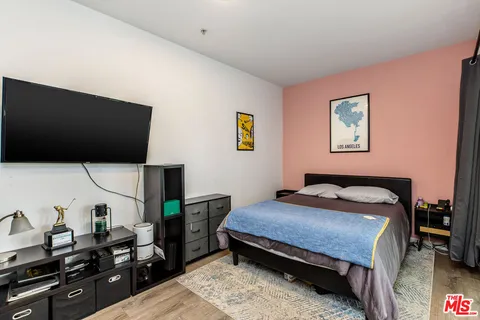 a bedroom with a bed and a flat tv screen on the table