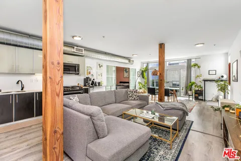 a living room with furniture wooden floor and a large window