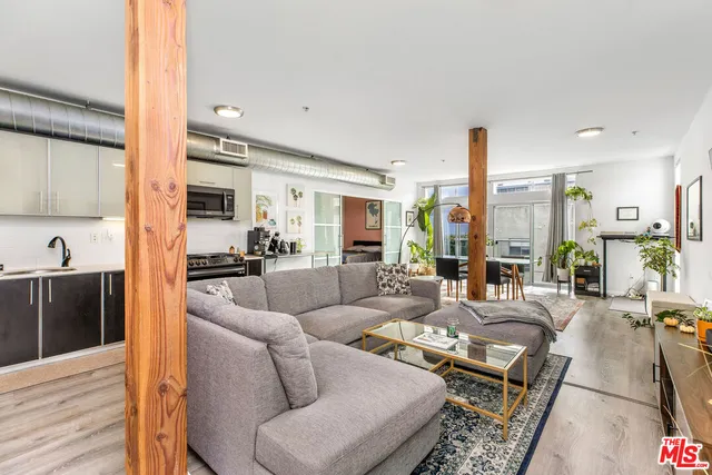 a living room with furniture wooden floor and a large window