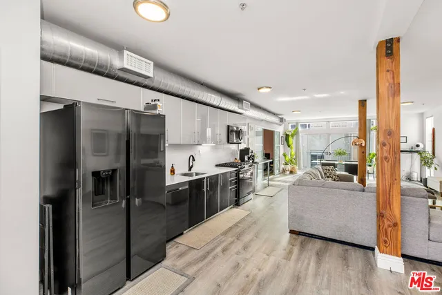 a large kitchen with a lot of counter top space and stainless steel appliances