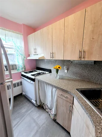 a kitchen with stainless steel appliances a sink a stove and white cabinets