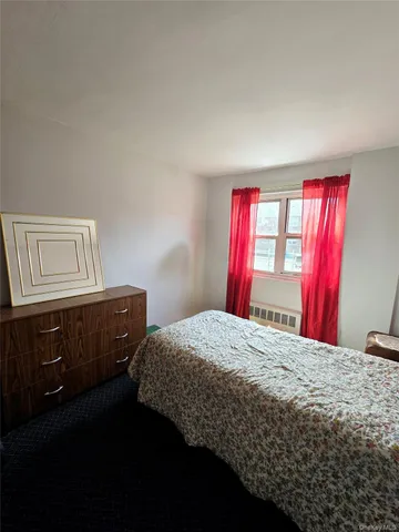 a bedroom with a bed dresser and a window