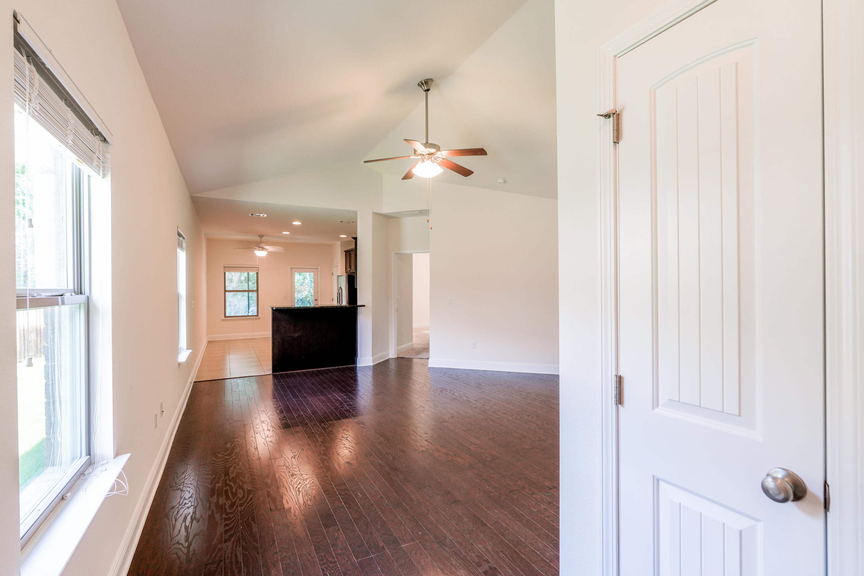 122 Riverbirch Loop Santa Rosa Beach, FL 32459 - Photo 3 of 41 a view of a hallway with wooden floor staircase and a kitchen