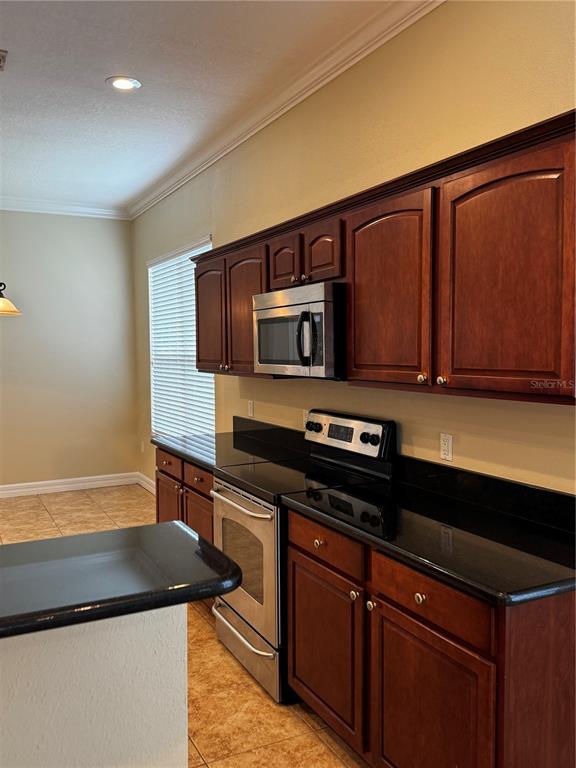 6871 Eagle Ridge Loop Lakeland, FL 33813 - Photo 14 of 42 a kitchen with stainless steel appliances granite countertop a stove a microwave and a sink