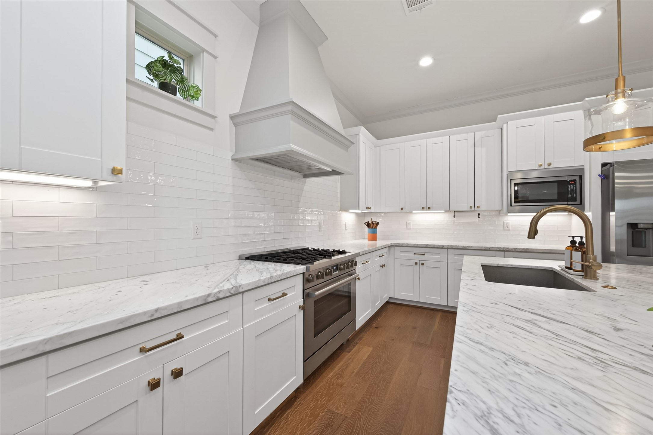 515 West 25th Street Houston, TX 77008 - Photo 9 of 35 Beautifully designed kitchen includes a classic subway tile backsplash, a stainless steel 36” 6-burner gas range, and a sleek range hood—bringing both performance and style to the heart of the home.