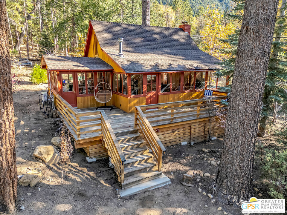 25250 Rim Rock Road Idyllwild, CA 92549 - Photo 1 of 72 a view of a patio with a table chairs and a barbeque