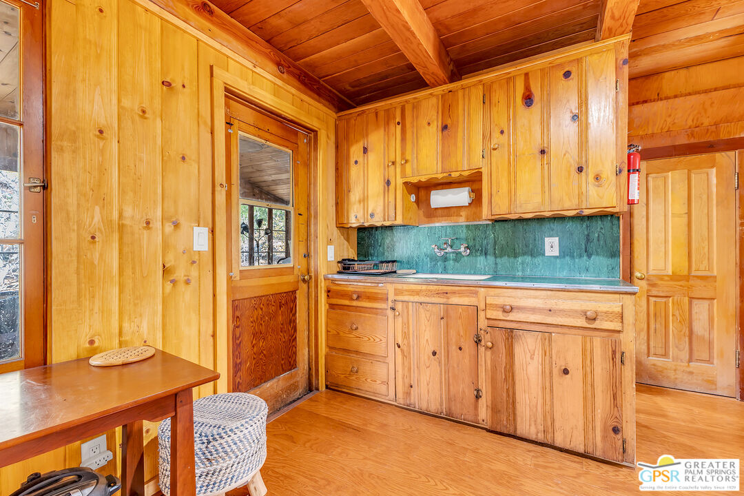 25250 Rim Rock Road Idyllwild, CA 92549 - Photo 22 of 72 a view of a kitchen with wooden floor and windows