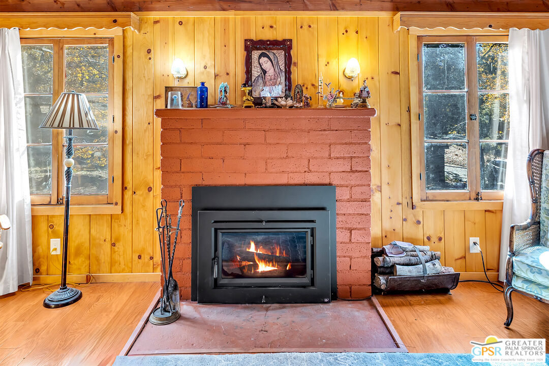 25250 Rim Rock Road Idyllwild, CA 92549 - Photo 30 of 72 a living room with furniture a fireplace and a potted plant with potted plants