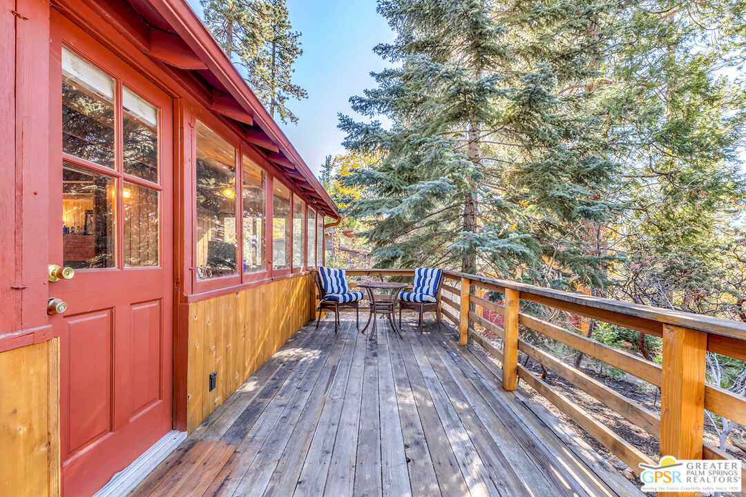 25250 Rim Rock Road Idyllwild, CA 92549 - Photo 49 of 72 a balcony with wooden floor and outdoor seating