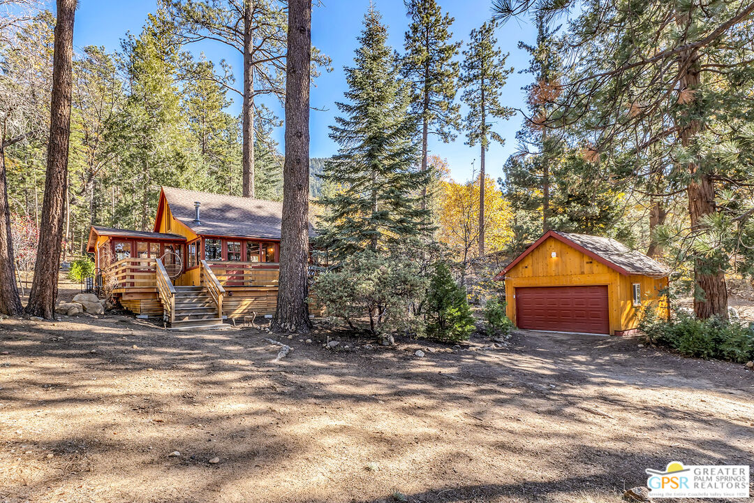 25250 Rim Rock Road Idyllwild, CA 92549 - Photo 59 of 72 a backyard of a house with large trees and outdoor seating