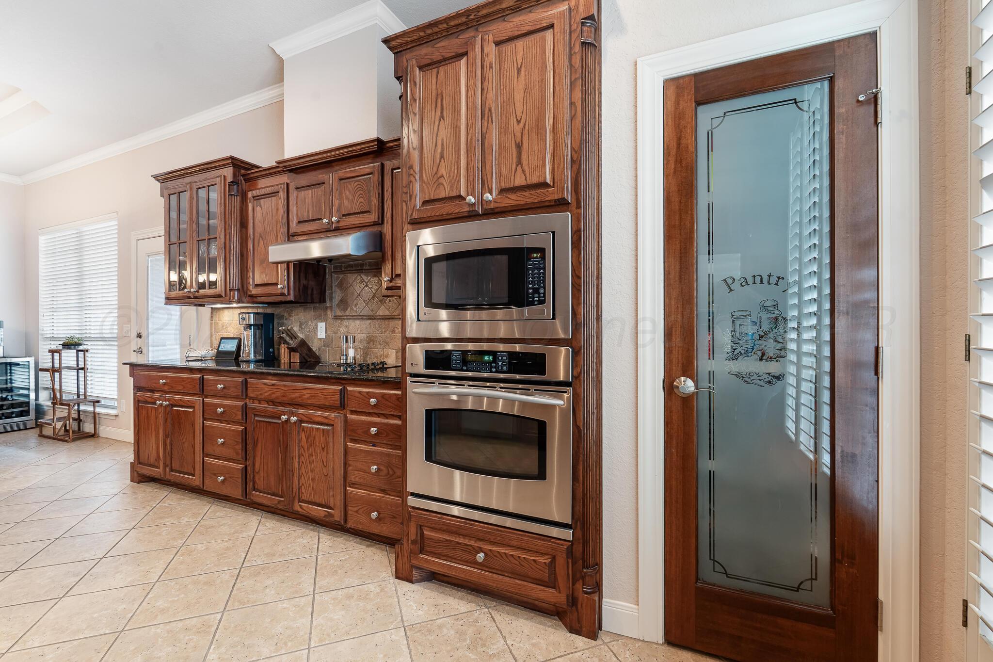 5008 Wesley Road Amarillo, TX 79119 - Photo 10 of 47 a kitchen with granite countertop a refrigerator and a stove top oven
