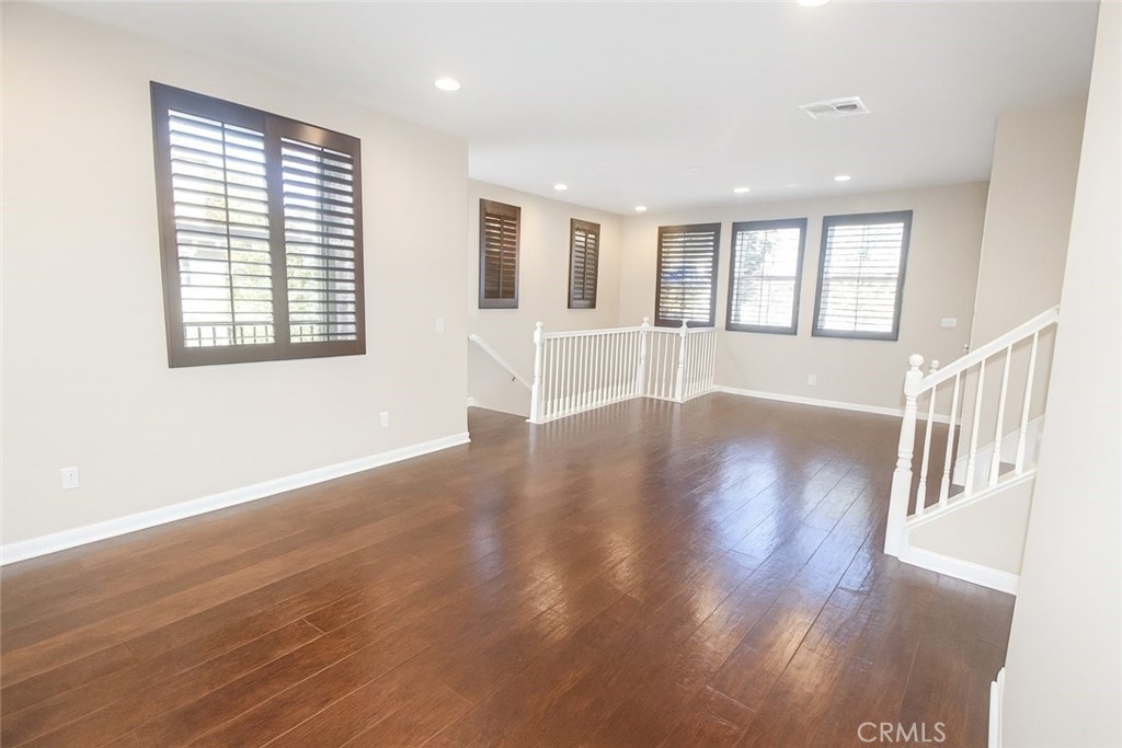 8045 Torino Stanton, CA 90680 - Photo 9 of 21 a view of an empty room with wooden floor and a window