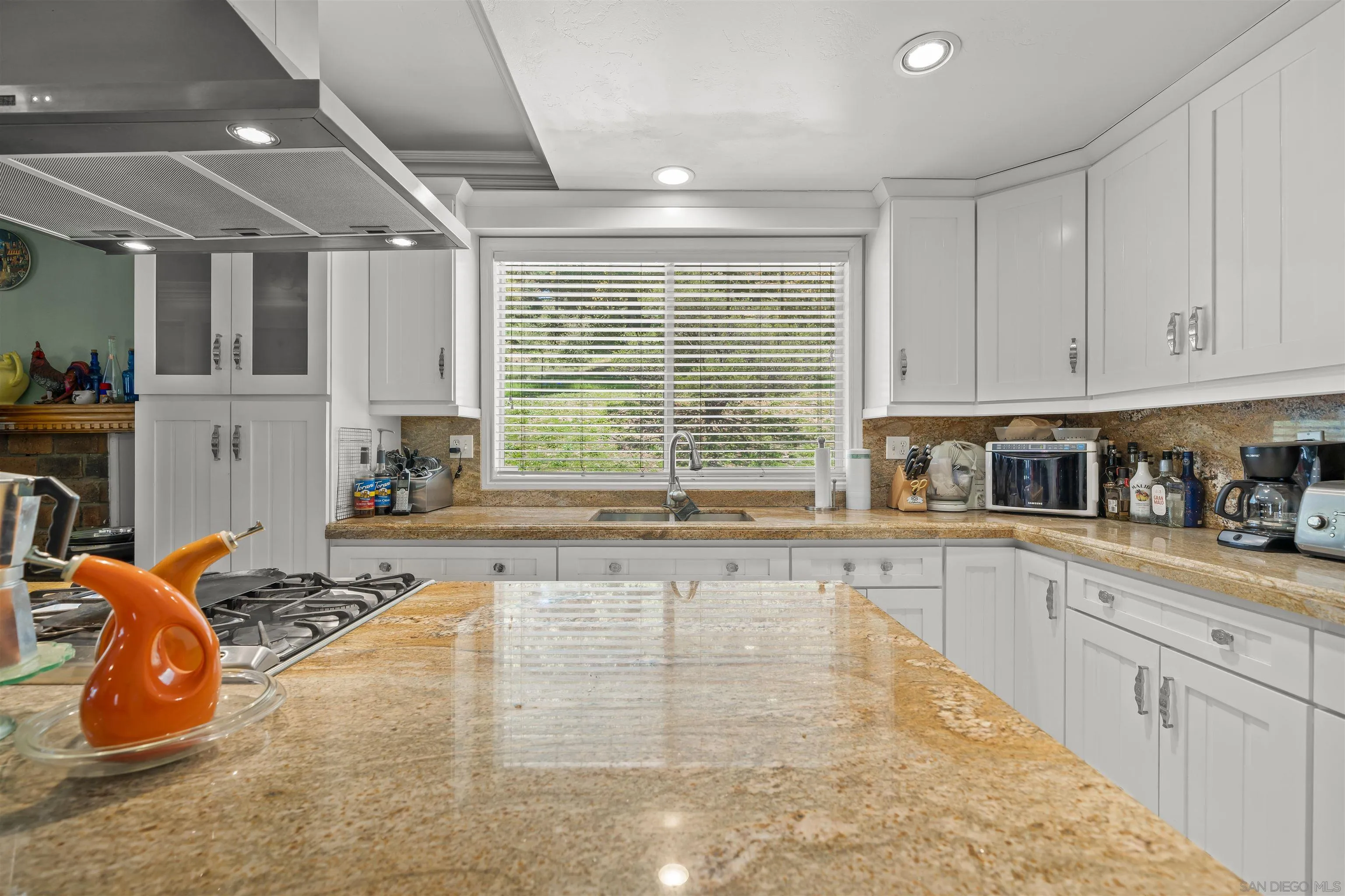 2464 Wynola Road Julian, CA 92036 - Photo 5 of 50 a large white kitchen with granite countertop a stove a sink a window and white cabinets