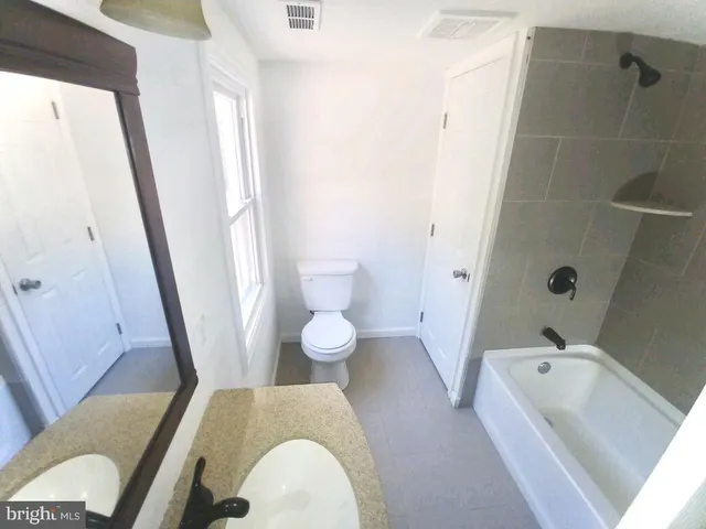 a bathroom with a tub a sink and a large mirror