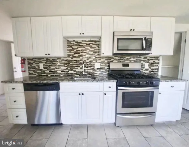 a kitchen with stainless steel appliances a stove sink and microwave