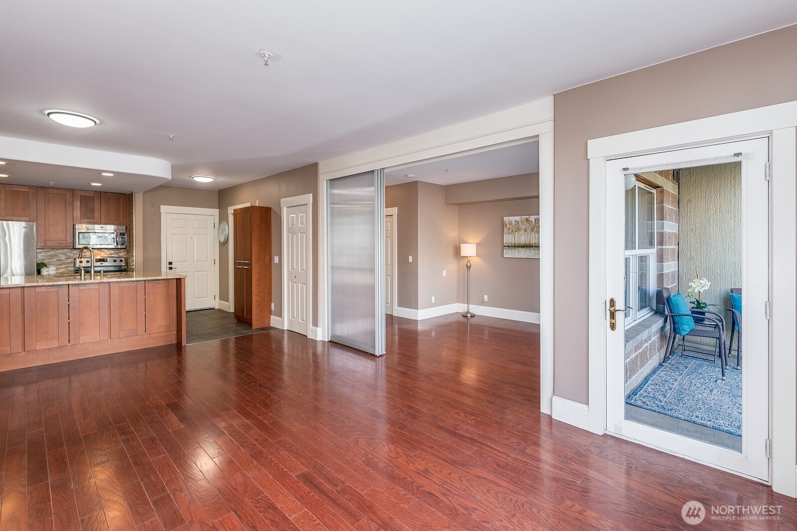 3221 Southwest Avalon Way, Unit 201 Seattle, WA 98126 - Photo 11 of 39 a view of a hallway with wooden floor and a kitchen