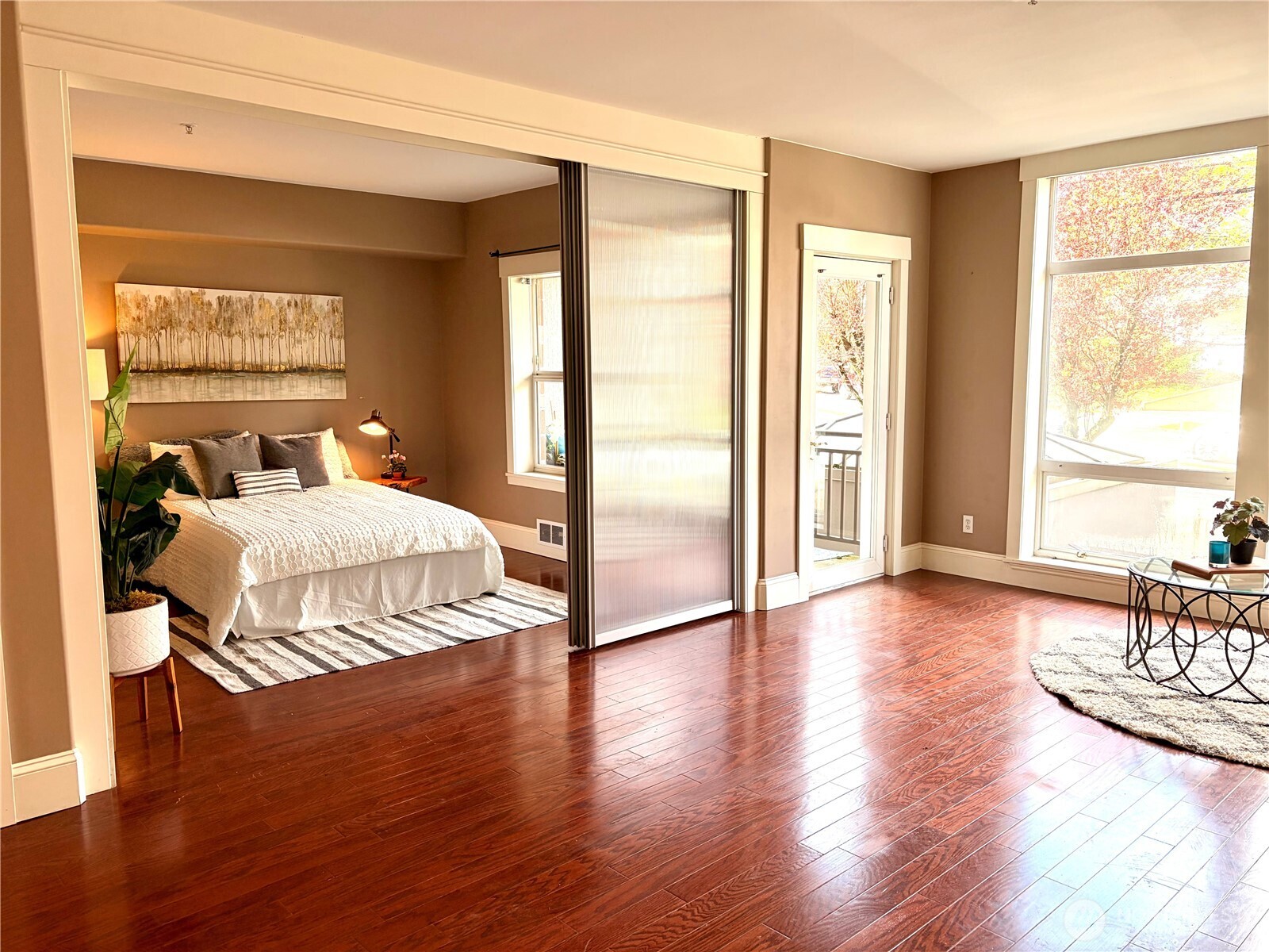 3221 Southwest Avalon Way, Unit 201 Seattle, WA 98126 - Photo 14 of 39 a bedroom with wooden floor and large window