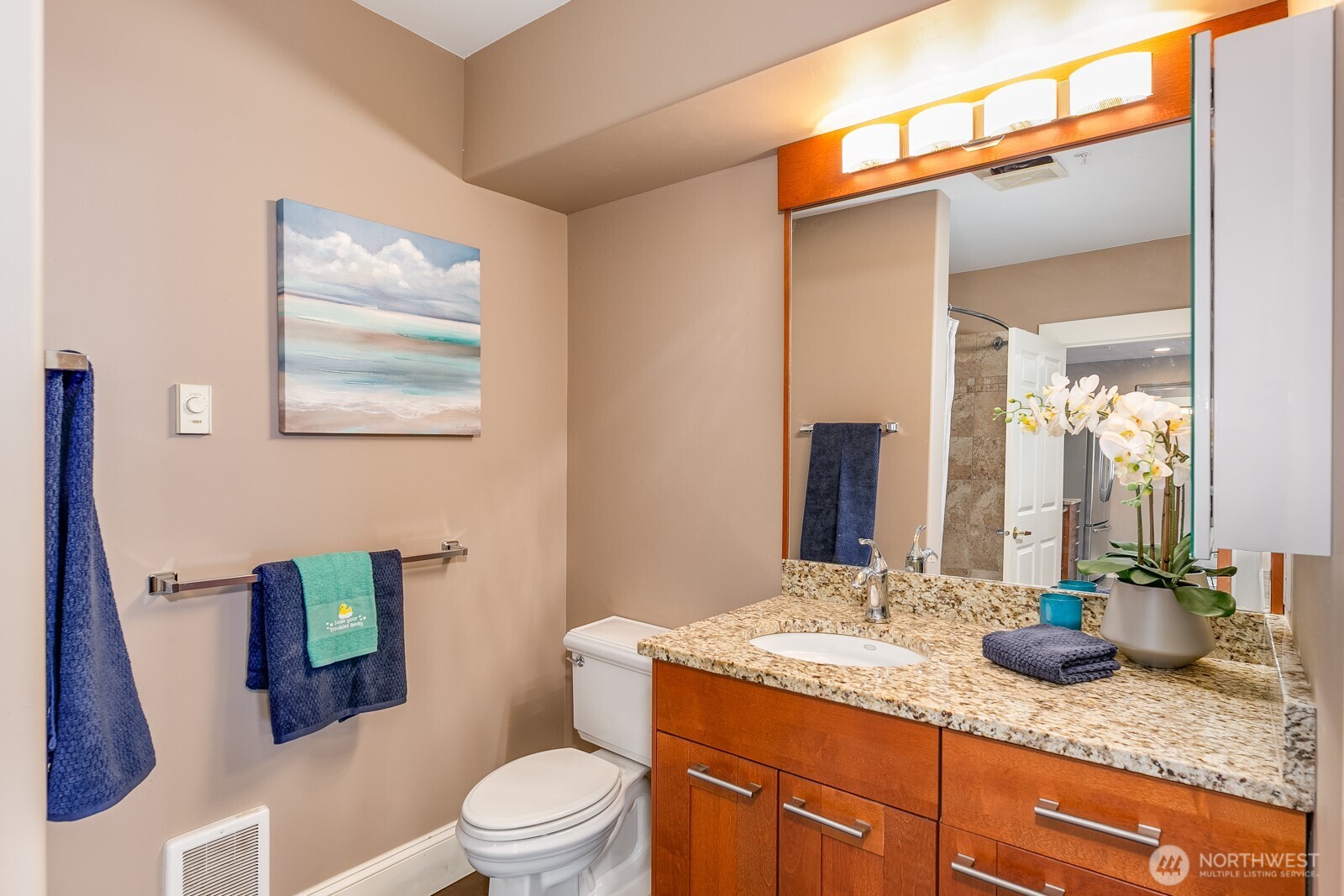 3221 Southwest Avalon Way, Unit 201 Seattle, WA 98126 - Photo 23 of 39 a bathroom with a granite countertop sink mirror vanity and toilet