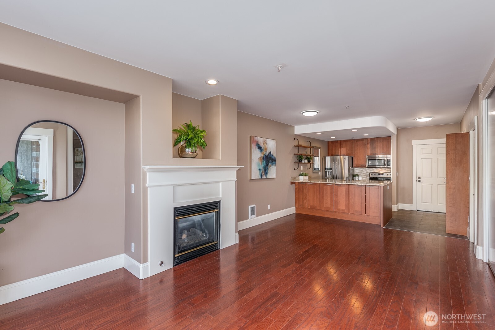 3221 Southwest Avalon Way, Unit 201 Seattle, WA 98126 - Photo 9 of 39 a view of a living room a kitchen with wooden floor and a fireplace