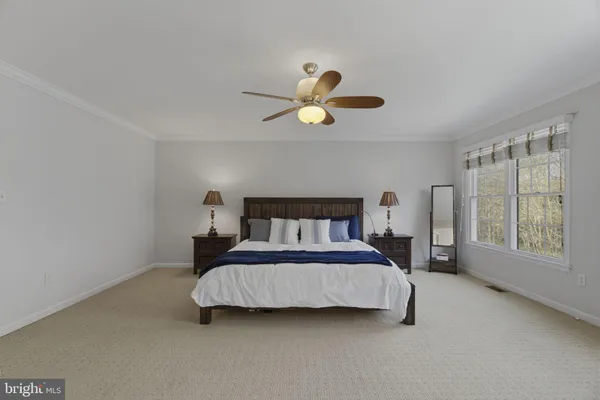 a bedroom with a bed ceiling fan and a window
