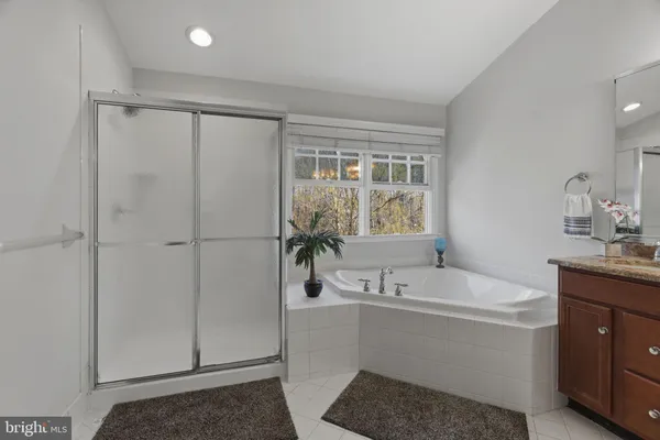 a bathroom with a tub a sink and a window