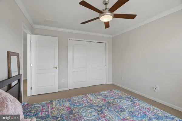 an empty room with a bed and a ceiling fan