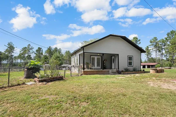 a view of a house with a yard and sitting area