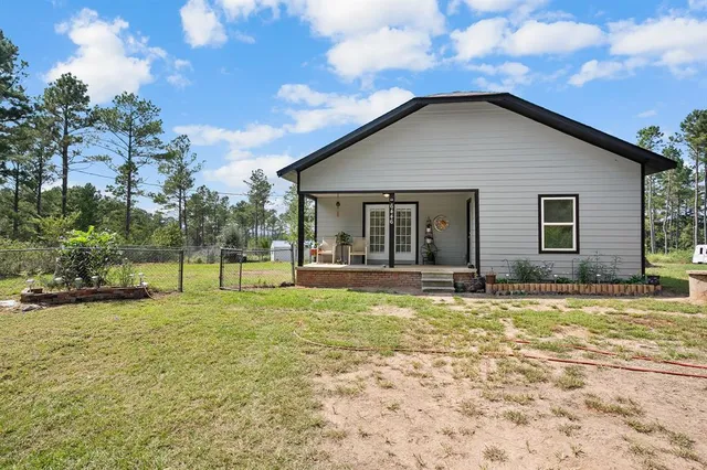 a view of a house with a yard and sitting area