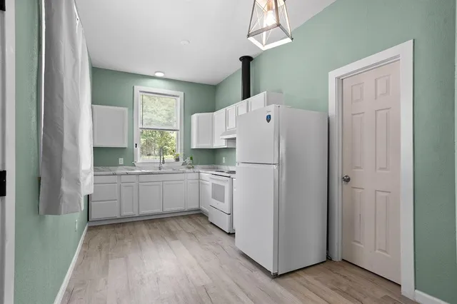 a kitchen with white cabinets and white appliances