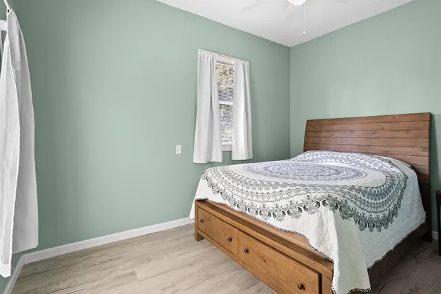 a bed sitting in a bedroom next to a window