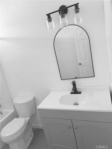 a white toilet sitting next to a bath tub