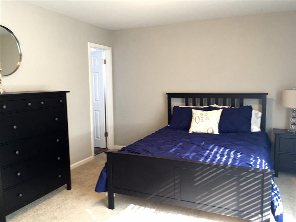 4883 Roswell Road, Unit N1 Atlanta, GA 30342 - Photo 8 of 15 a bedroom with a bed and a dresser