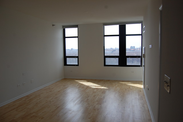 1255 South State Street, Unit 704 Chicago, IL 60605 - Photo 3 of 14 an empty room with wooden floor and windows