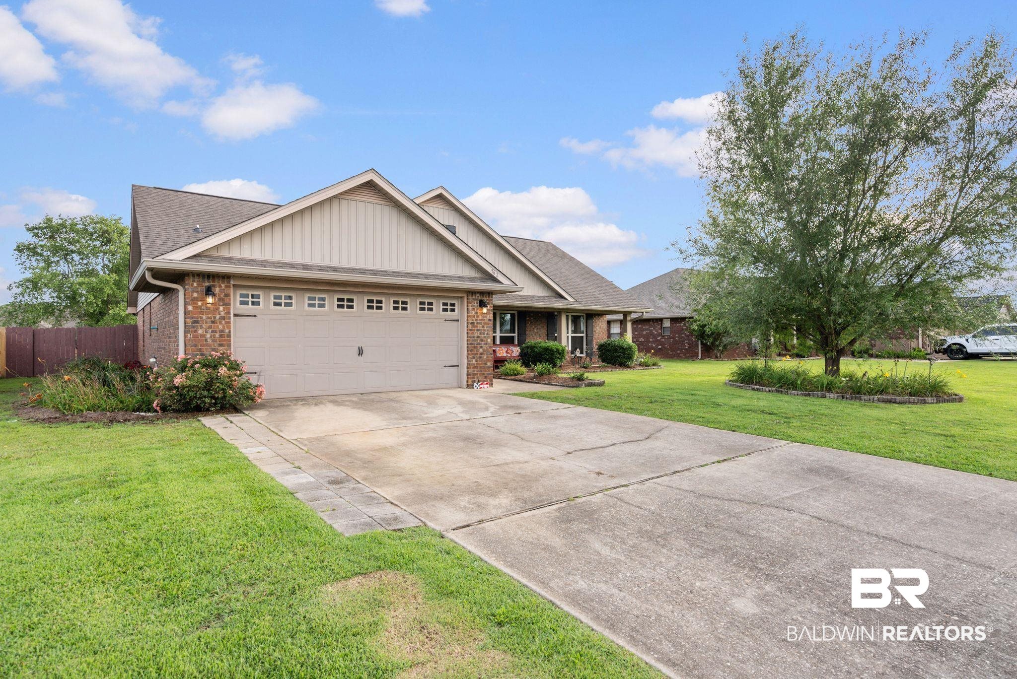 562 Vestige Mews Foley, AL 36535 - Photo 3 of 54 Brick and siding exterior featuring a two-car garage with decorative hardware and window inserts