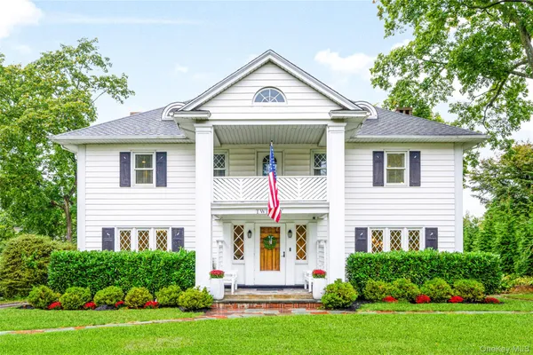 a front view of a house with a yard and trees