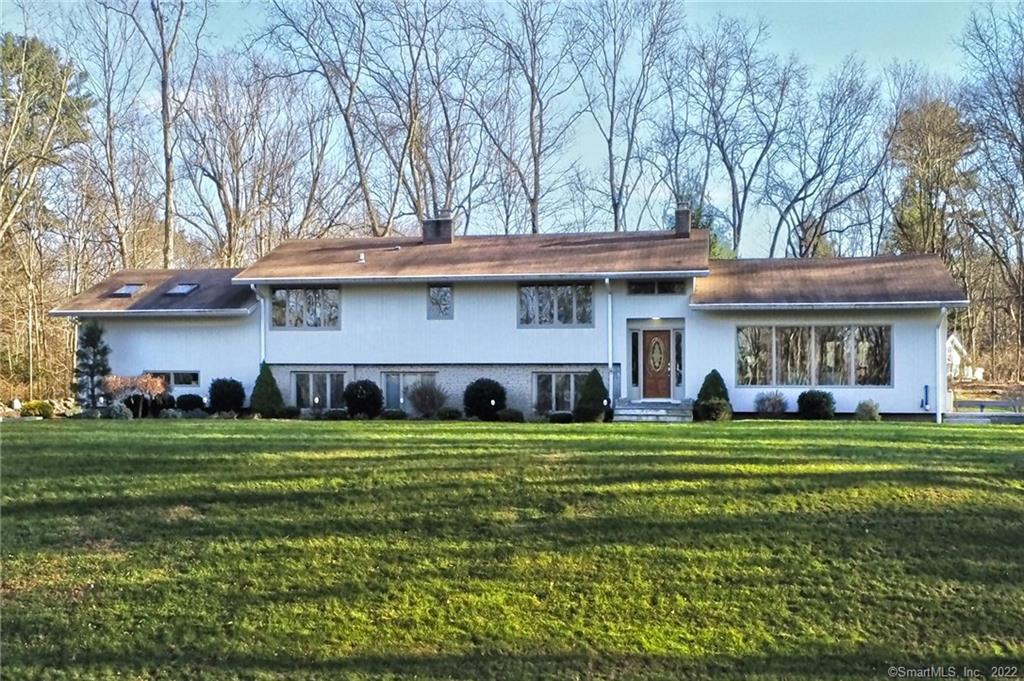 a front view of a house with a garden and trees