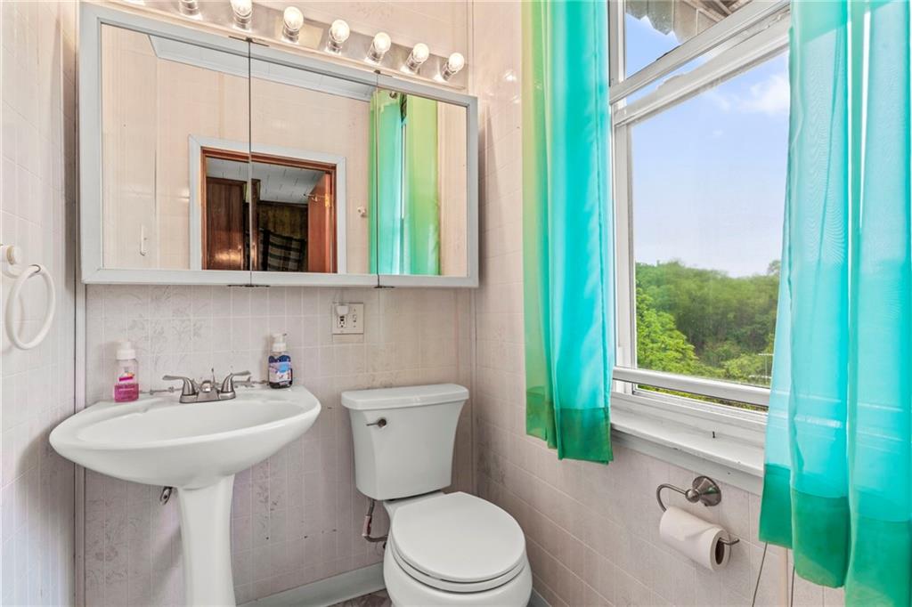 1908 St Paul Street Pittsburgh, PA 15203 - Photo 18 of 28 a bathroom with a sink a toilet and mirror