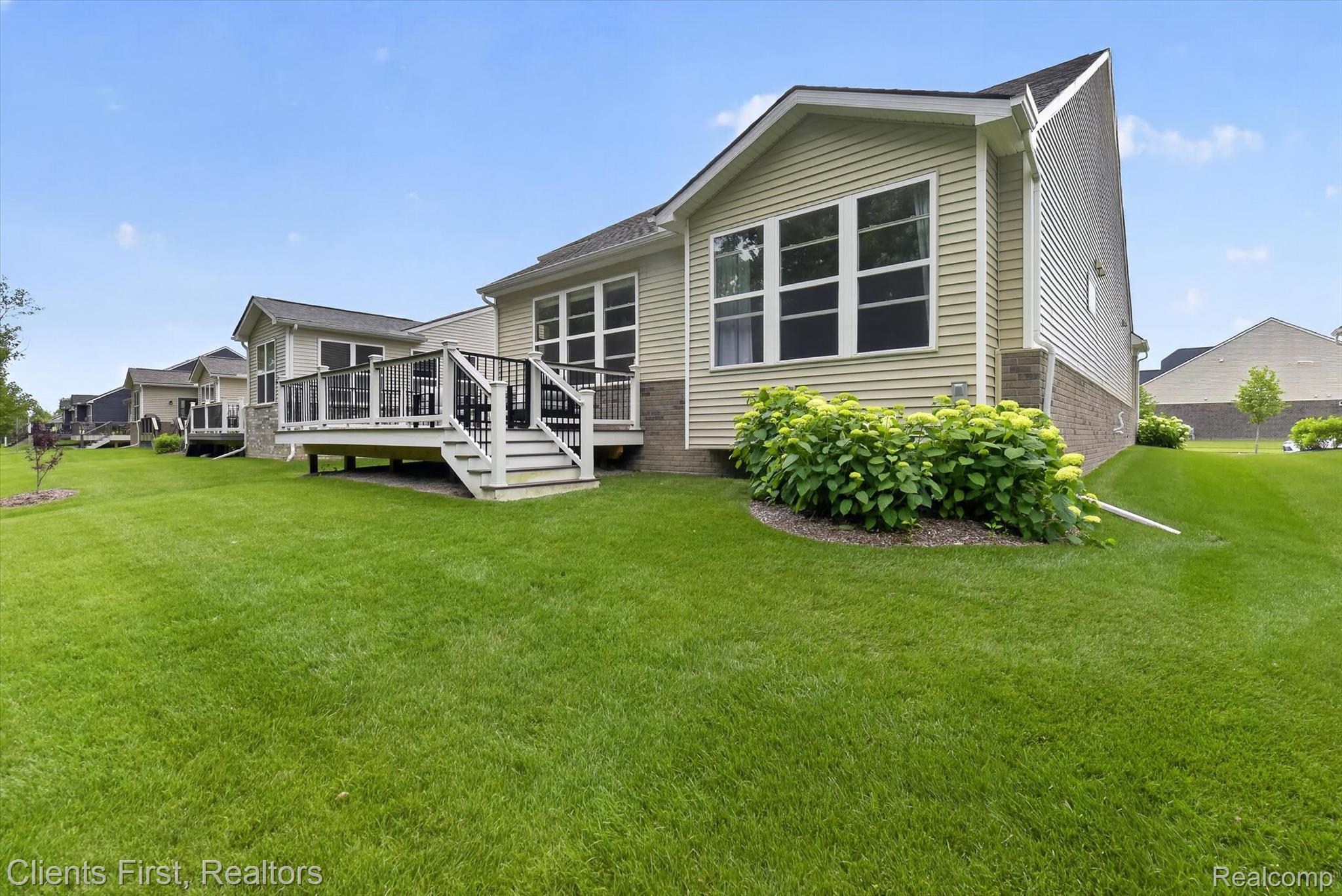 4699 Bingham Road Canton, MI 48188 - Photo 43 of 47 Rear exterior featuring light-colored siding, a multi-level deck with white and black railing, and a stone accent foundation