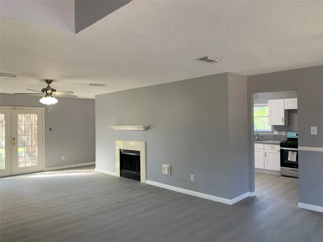 wooden floor fireplace and windows in an empty room