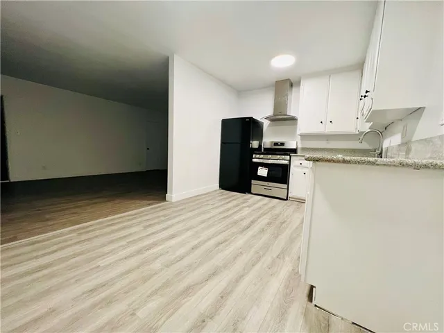 a kitchen with granite countertop a refrigerator stove top oven and sink
