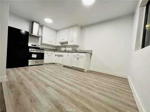 a kitchen with granite countertop a refrigerator stove top oven and sink