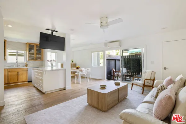 a living room with furniture and view of kitchen