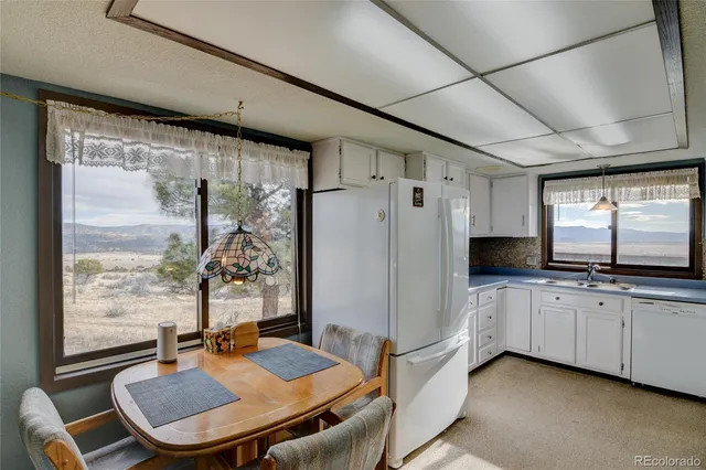 a kitchen with granite countertop white cabinets and white appliances