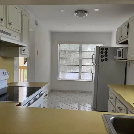 a kitchen with granite countertop cabinets stainless steel appliances and a sink