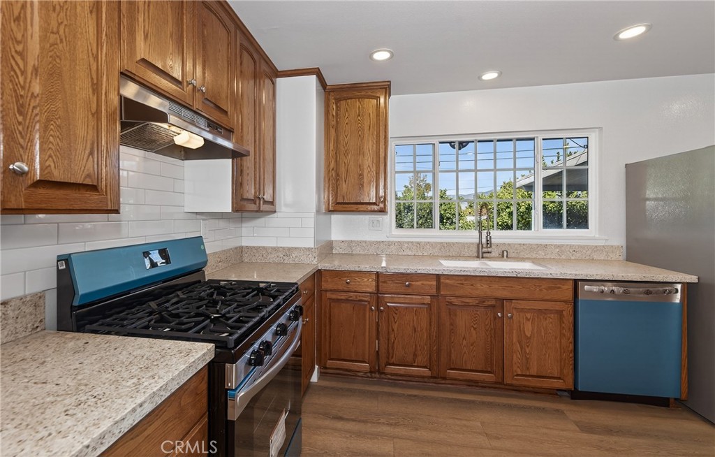 201 Primrose Avenue Redlands, CA 92373 - Photo 13 of 23 a kitchen with stainless steel appliances granite countertop a stove a sink and a microwave