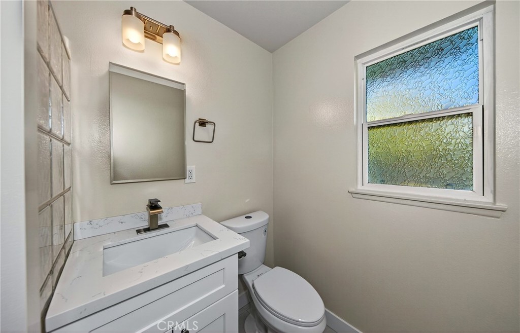 201 Primrose Avenue Redlands, CA 92373 - Photo 19 of 23 a bathroom with a sink vanity mirror and toilet