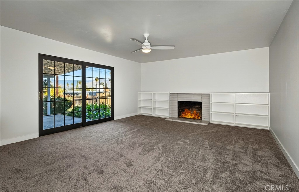 201 Primrose Avenue Redlands, CA 92373 - Photo 7 of 23 a view of an empty room with a fireplace and a window